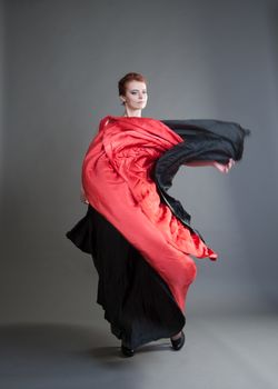 flamenco dancer swinging skirt on a grey background