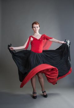 flamenco dancer swinging skirt on a grey background