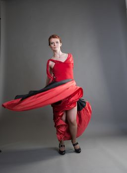 flamenco dancer swinging skirt on a grey background