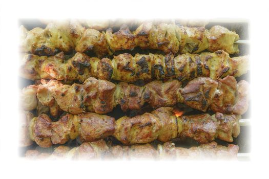 Grilled marinated caucasus barbecue meat shashlik (shish kebab) pork meat grilling on metal skewer outdoor, close up