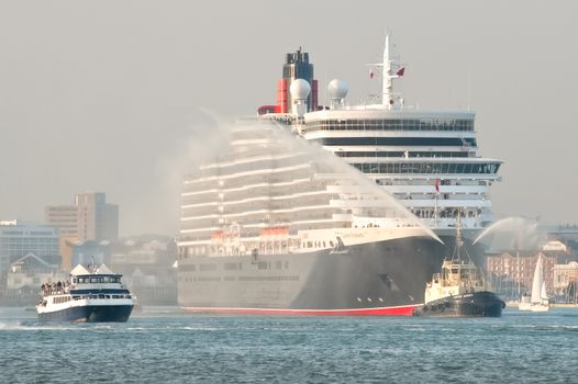 Southampton, UK - October 12, 2010: A hazy sunset departure from port for the Queen Elizabeth cruise liner on her maiden voyage from Southampton, UK