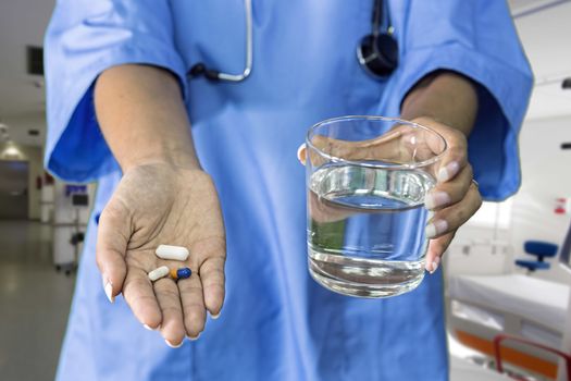 picture of doctor hands giving white pills and glass of water