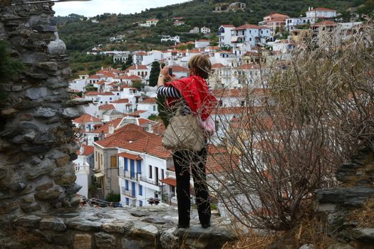 Lady takes photo of the Skopelos town on the Greek island Skopelos