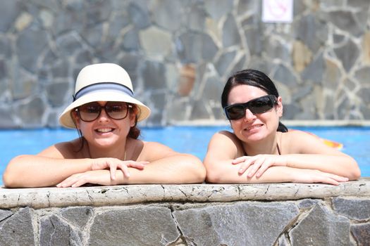 Happy friends in the pool. Focus in the right lady.