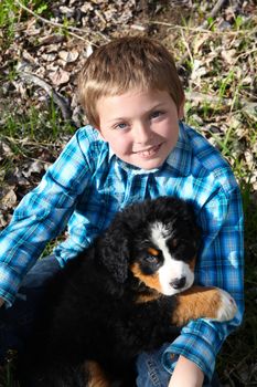 Young boy with his Bernese Mountain Dog puppy 