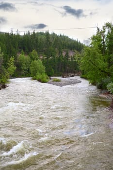 Rising river flowing around an island of rocks