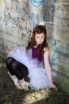 Beautiful girl wearing a white tutu against graffiti wall