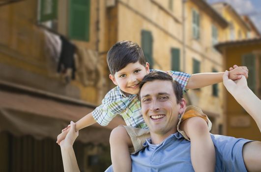 Mixed Race Father and Son Playing Piggyback on the Streets of France.