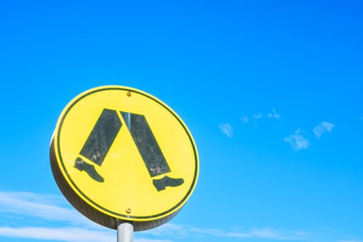 the crossing sign under the blue sky