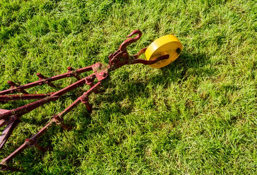 Farming tool on the green field is waiting to be used