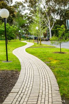 A brick footpath laid from one side of the park to the other side.