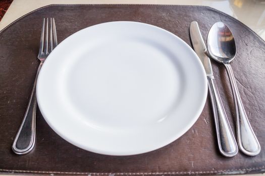 White plate with spoon knife and fork, stock photo