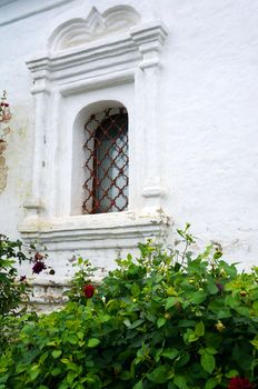 Barred window - Detail of an old white church                               