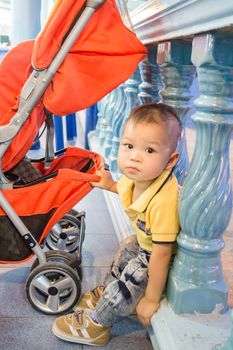Asian cute boy pose with baby stroller, stock photo