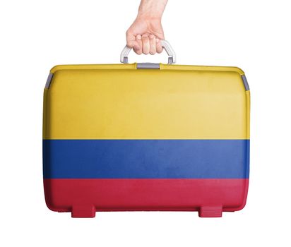 Used plastic suitcase with stains and scratches, printed with flag, Colombia