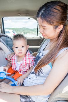 Asian boy sitting in the car with his mother, stock photo