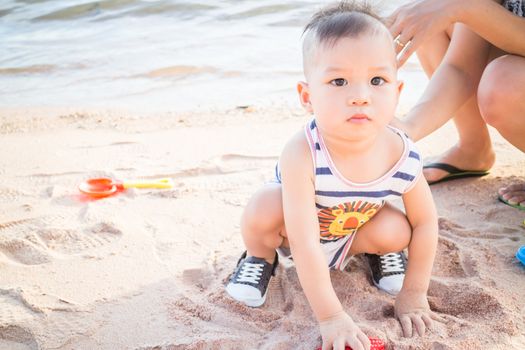 Little cute boy playing sand on the beach, stock photo