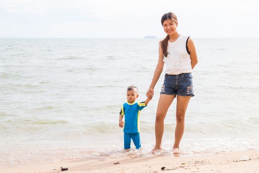 Son and mom chill on the beach, stock photo