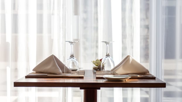 A simple and beautifully arranged table for two, with cloth napkins and wine glasses