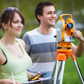 Two young land surveyors at work