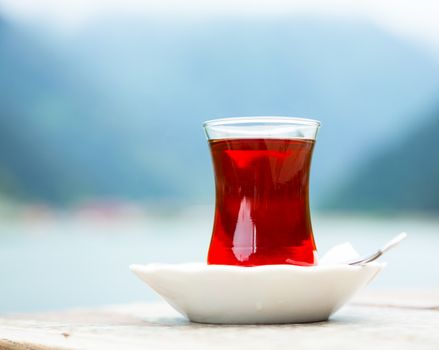 Turkish tea served in traditional glass and plate against mountains
