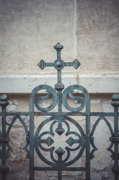 iron cross, fence with decorative metal flourishes