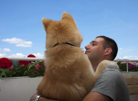 Japanese seven-month dog Akita inu ,posing with young man,his owner, in Belgrade,Serbia