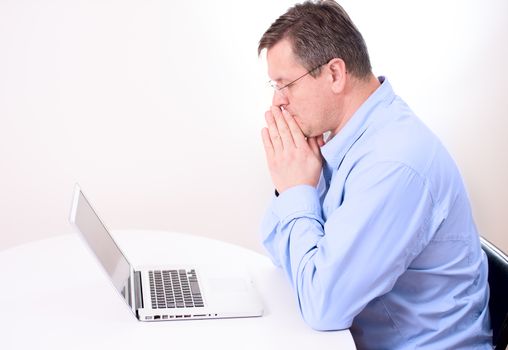 Man thinking hard on front of laptop