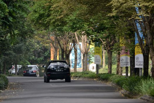 bandung, indonesia-june 9, 2014-black colored toyota harrier cruising on the road