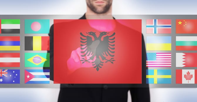 Hand pushing on a touch screen interface, choosing language or country, Albania