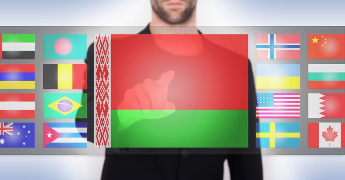 Hand pushing on a touch screen interface, choosing language or country, Belarus