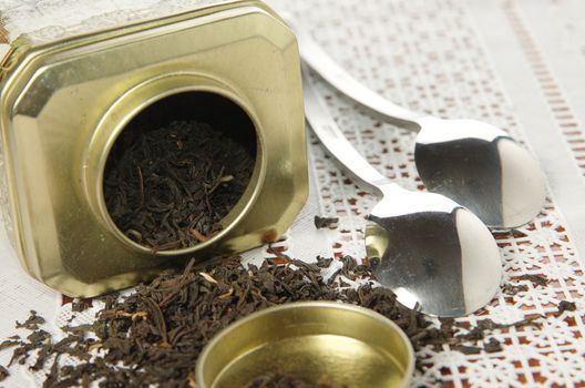 A silver spoon next to two jars of tea