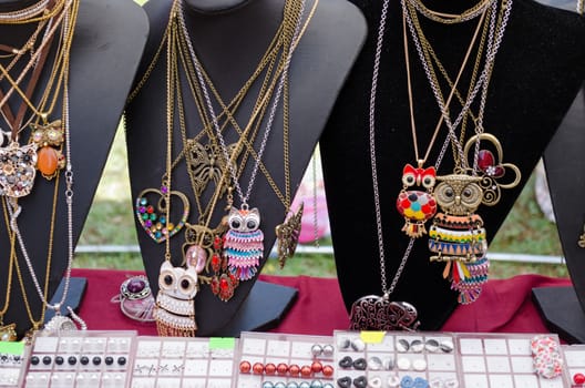 female owl shaped pendant necklaces and other decorations on three black stand city market