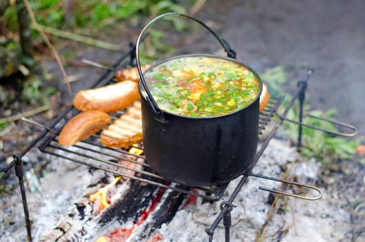 The cooking of soup on the fire on the camping