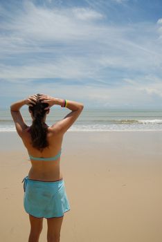 Stock photo of beautiful tall brunette woman on the beach in the tropics