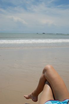 Stock photo of beautiful tall brunette woman on the beach in the tropics