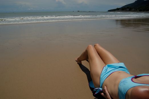 Stock photo of beautiful tall brunette woman on the beach in the tropics