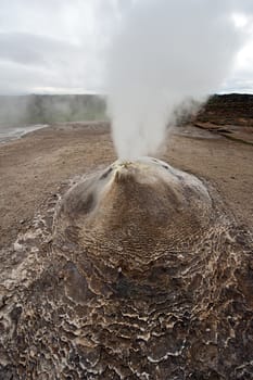 Fumarole in the geothermal area Hveravellir, central Iceland. The area around is layered and cracked. 