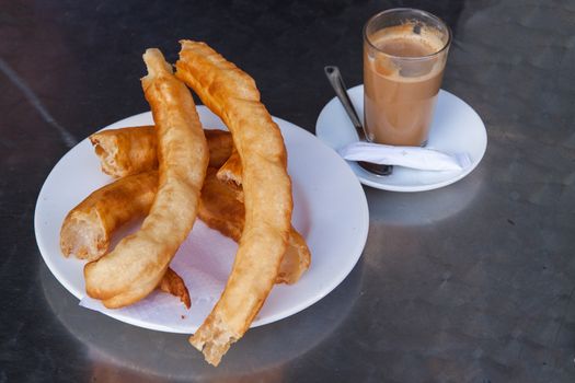 Glass of coffee with churros - typical breakfast in Spain