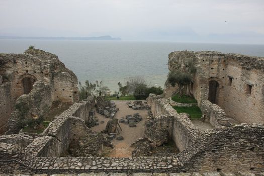  Roman ruins of Catull Grottos in rainy day at  Sirmione, Lake Garda, Italy.