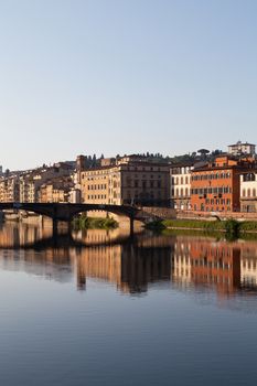 view on bridge on arno river in florence in italy with reflection