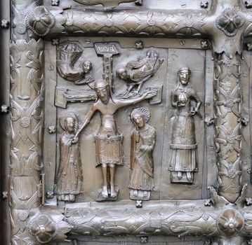 Ancient bronze gates of Magdeburg in Veliky Novgorod, Russia. Fragment of the bas-relief with Jesus crucified on the cross.