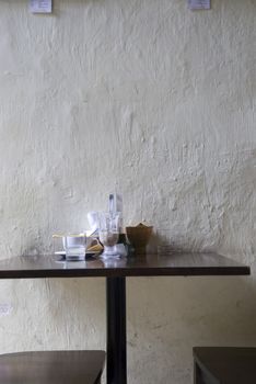 A table and chair set against a wall in a cafe, Melaka, Malaysia