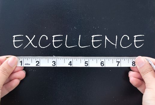 Tape measure against the word excellence 