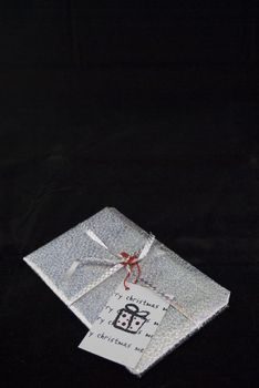 A silver christmas gift isloated on a black background