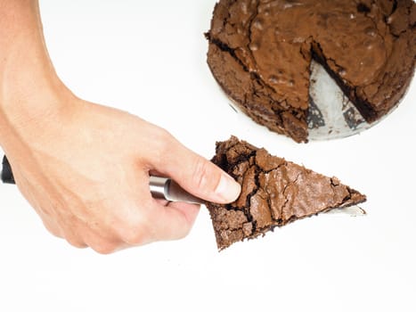 Person serving a slice of fresh made chocolated cake