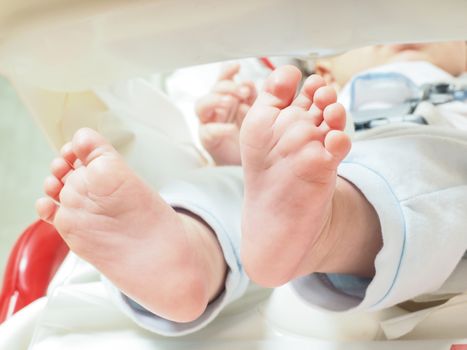 Baby feet stretching at  feeding table with blue clothes