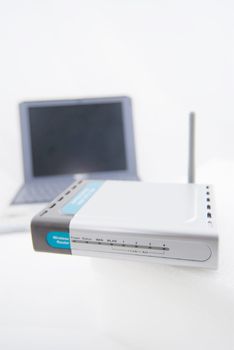 A modern silver laptop with wireless router