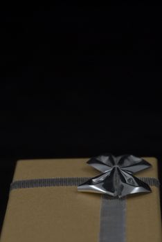 Christmas gift with silver bow on black background