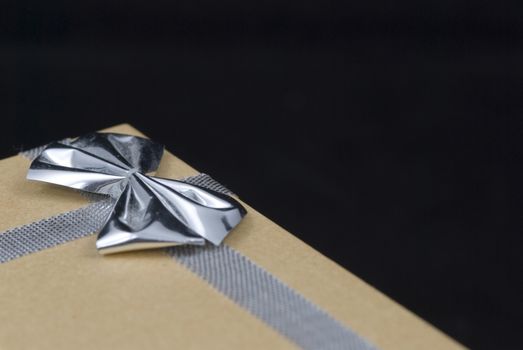 Christmas gift with silver bow on black background